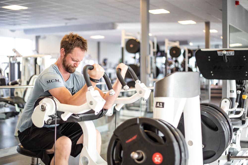 Man på gymmet som kör bicep curls